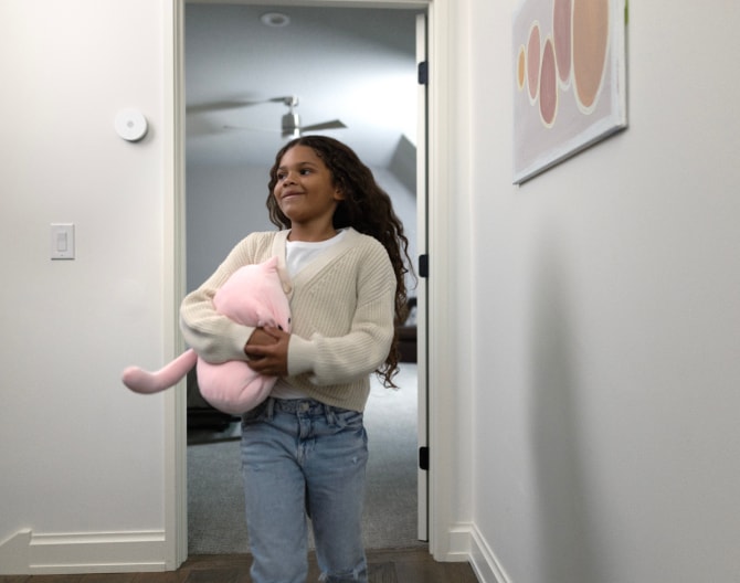 Child walking into her house with an ADT Indoor Siren on the wall Child walking into her house with an ADT Indoor Siren on the wall