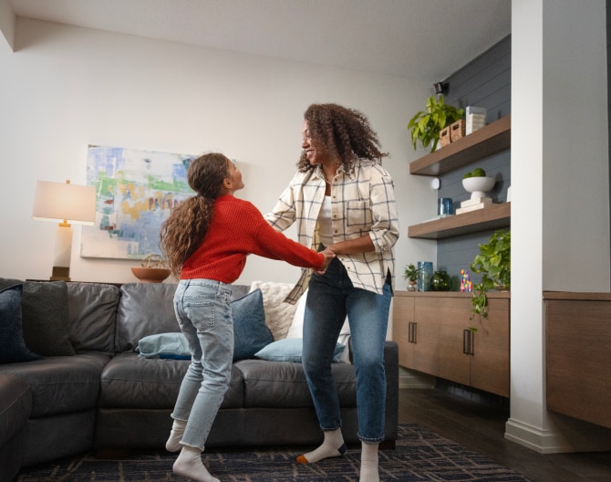 Mother and daughter dancing in the living room with an ADT Motion Sensor installed Mother and daughter dancing in the living room with an ADT Motion Sensor installed